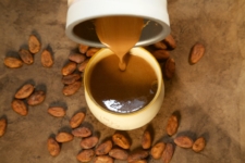 Pouring Hot Cocoa Into Mug With Cacao Beans